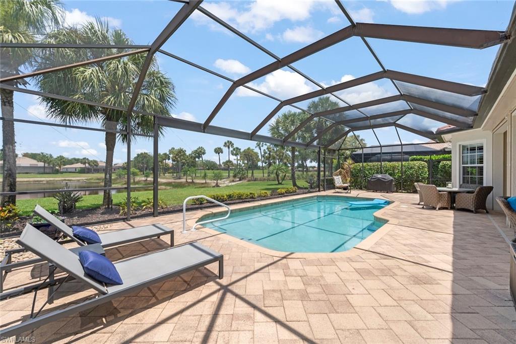 In ground pool with brick paver deck and large picture screen overlooking the lake