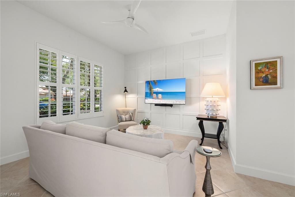 Den with custom millwork accent wall, new fan, new luxury vinyl flooring and plantation shutters