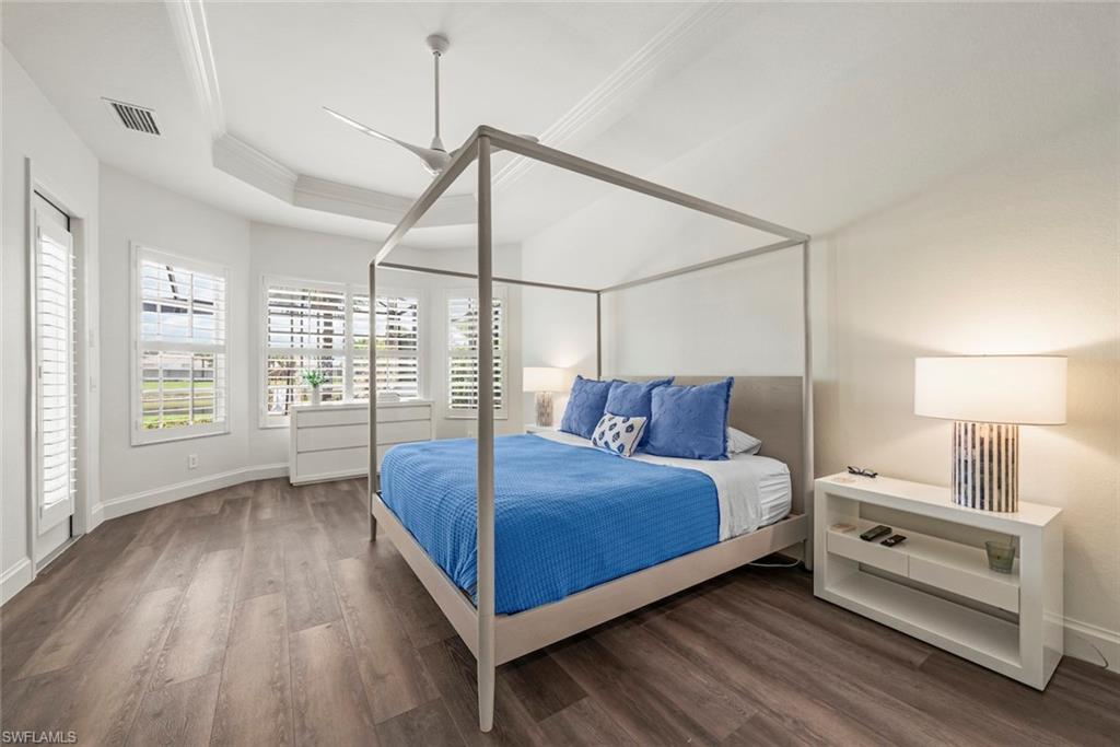 Primary bedroom with new luxury vinyl flooring, trey ceiling and plantation shutters on the windows.