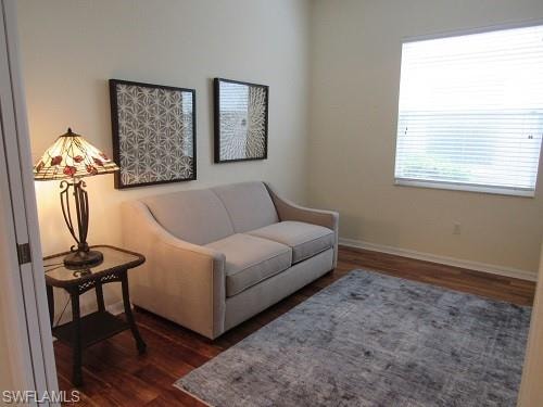 Sitting room with dark wood-style floors and baseboards