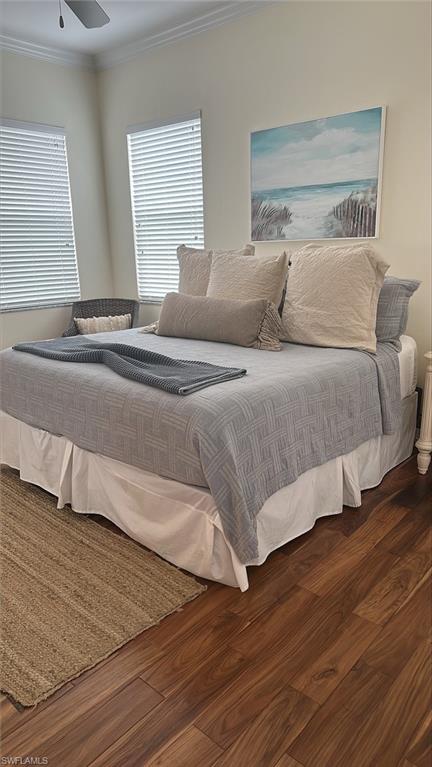 Bedroom featuring wood finished floors and crown molding