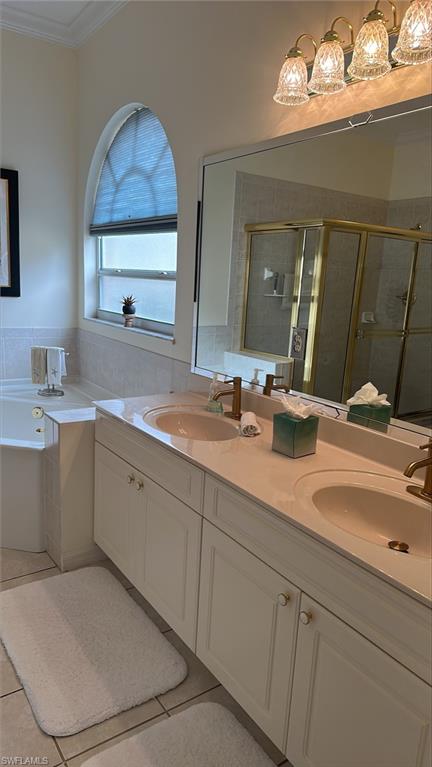 Full bathroom with tile patterned flooring,  sink, molding, and a shower stall