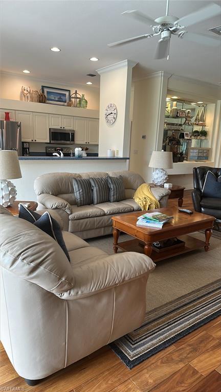 Living area featuring crown molding, light wood-style floors, ceiling fan, and recessed lighting
