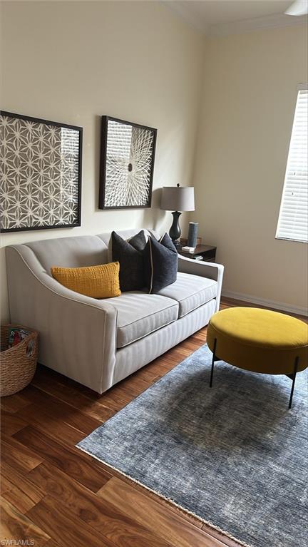 Living room with crown molding and wood finished floors
