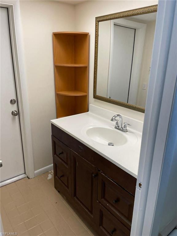 Updated bathroom vanity with integrated sink, polished chrome faucet, and dark wood cabinetry — clean and well-appointed