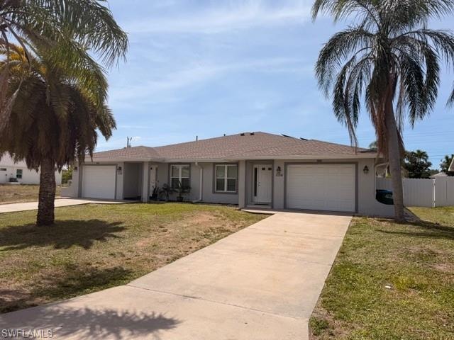 Attractive duplex featuring individual driveways, single-car garages, and lush landscaping with mature palm trees — great curb appeal for this income-producing property