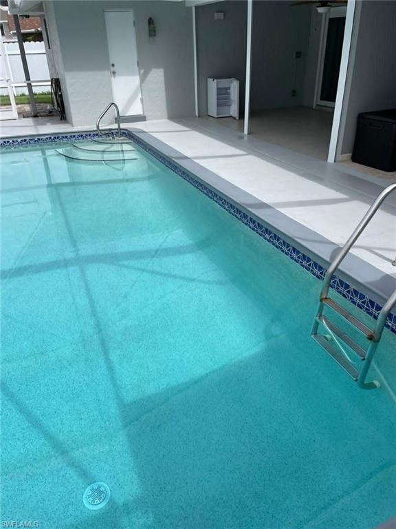 Inviting in-ground pool with tiled waterline, built-in steps, and safety handrails — a premium feature for tenant retention