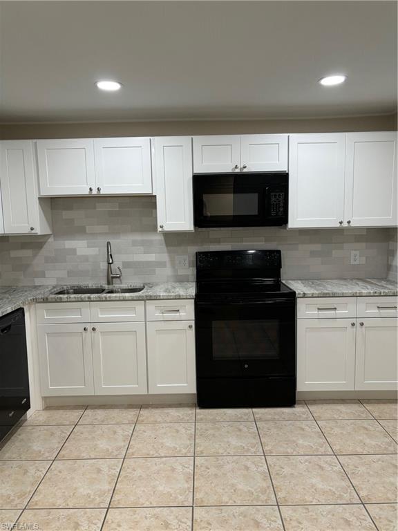 Kitchen with tasteful backsplash, sink, range, dishwashing machine, and white cabinets