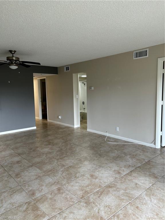 Living room with a textured ceiling and ceiling fan