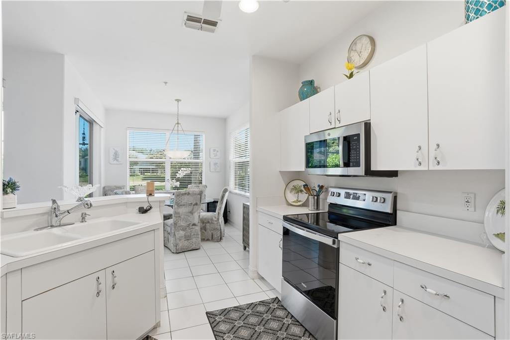 Modern kitchen featuring white cabinetry, a double basin sink, and stainless steel appliances