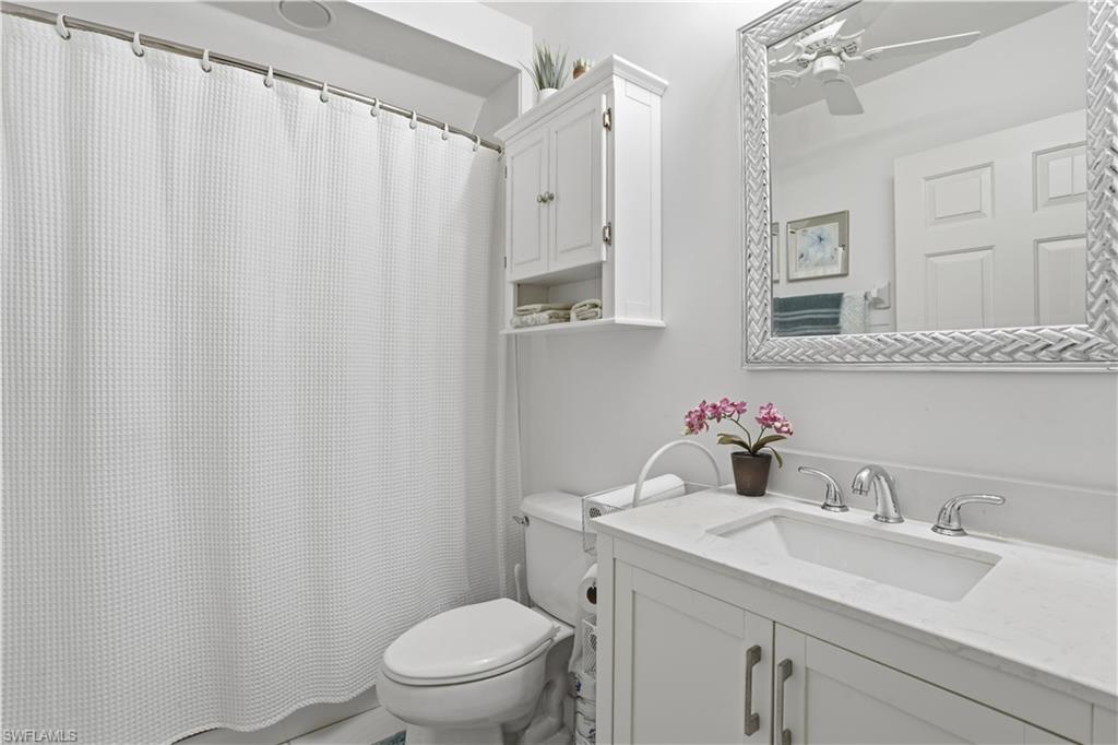 Bathroom with a white vanity featuring a rectangular undermount sink, a polished chrome widespread faucet, and a light-colored countertop