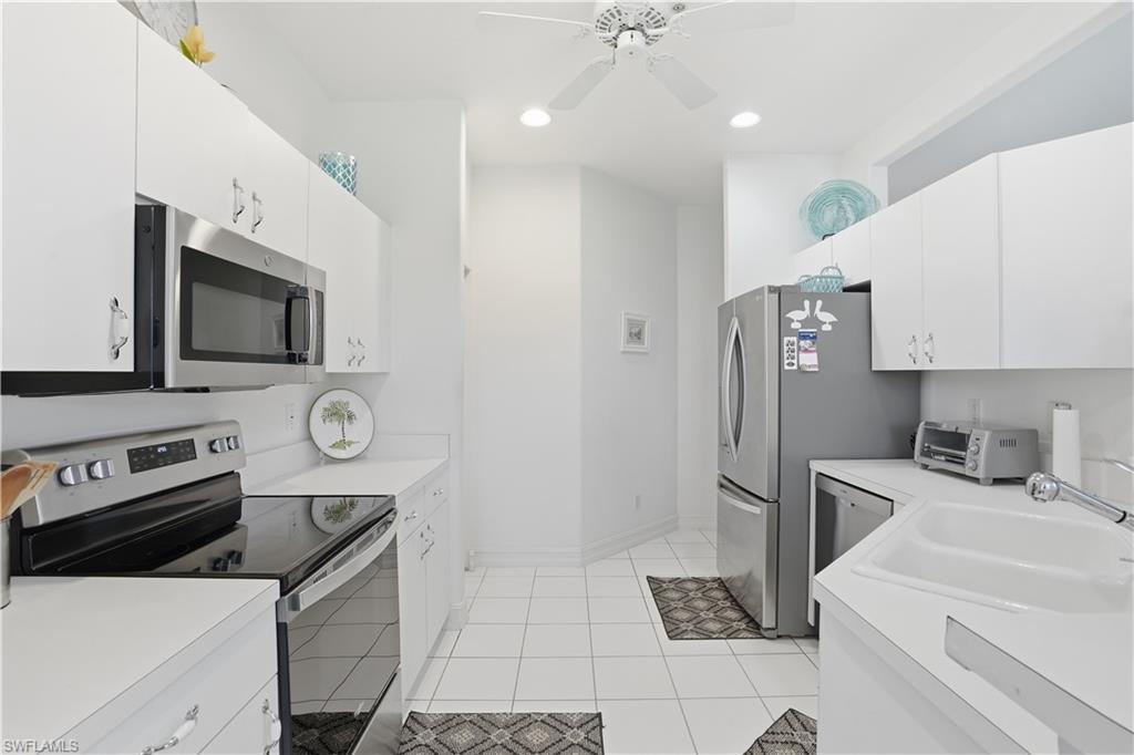 Kitchen featuring white cabinetry, white countertops, stainless steel appliances, a white ceiling fan, and recessed lighting