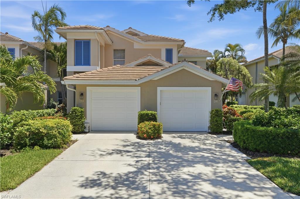Two-story residence featuring a tile roof, stucco exterior, and a two-car garage