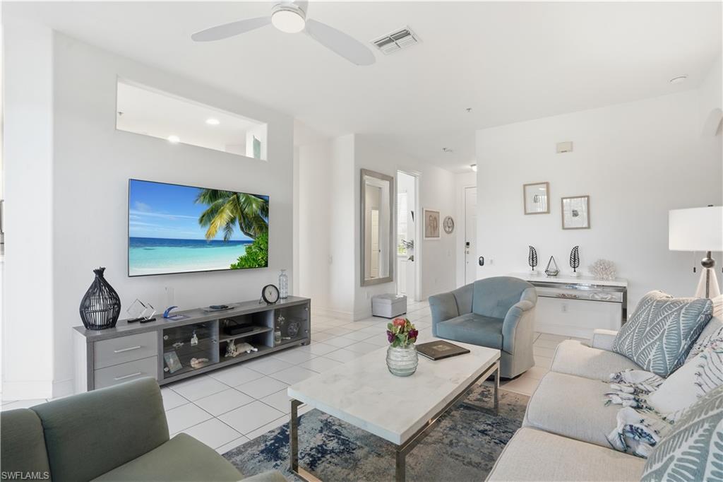 Bright living space featuring white tile flooring and high ceilings