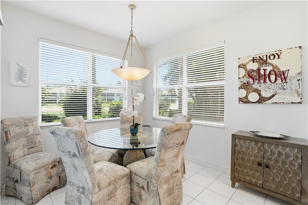 Dining area featuring a contemporary ceiling fixture, two large windows with horizontal blinds, and tile flooring