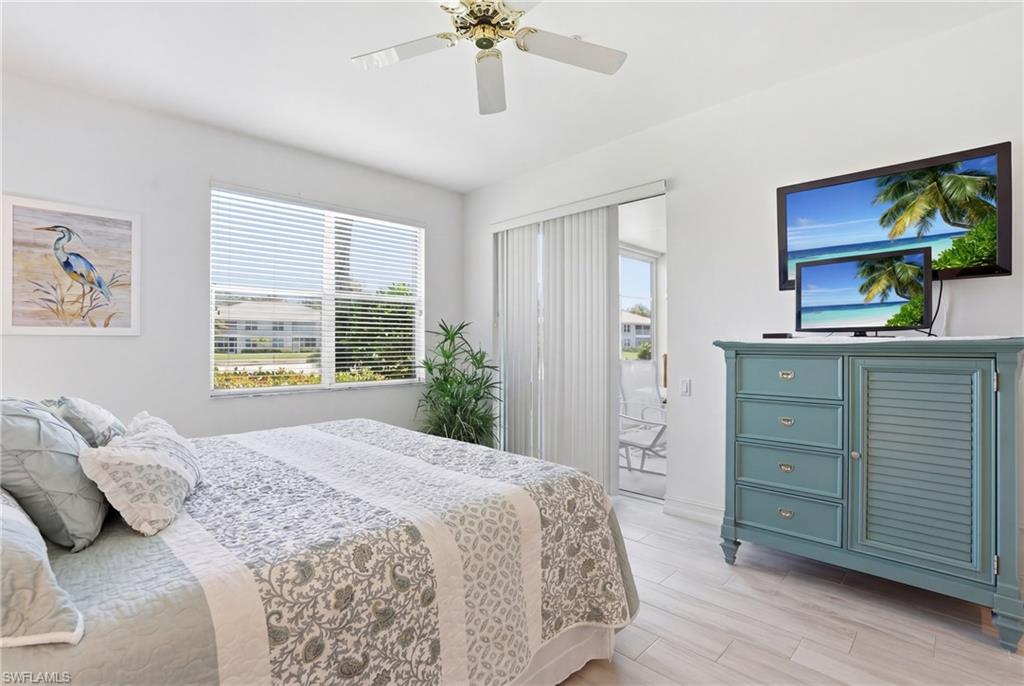 Bright interior with a ceiling fan, white window blinds, light wood-finish flooring, and a sliding glass door opening to an exterior patio