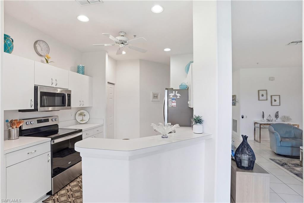 Kitchen featuring white cabinetry, stainless steel microwave, and a black and stainless steel range