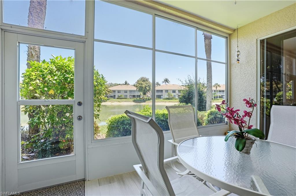Screened lanai featuring a waterside setting with distant structures, glass panel sliding door, and textured wall finish