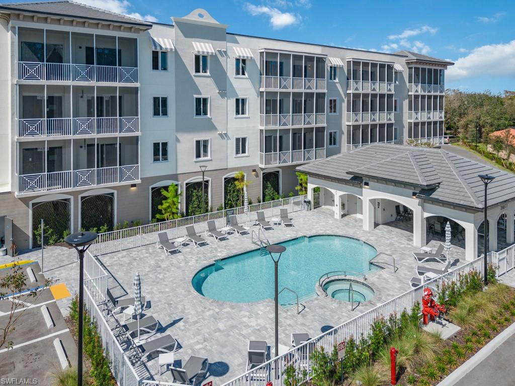 Outdoor recreation area featuring a swimming pool, integrated spa, and an adjacent covered cabana with a tiled roof
