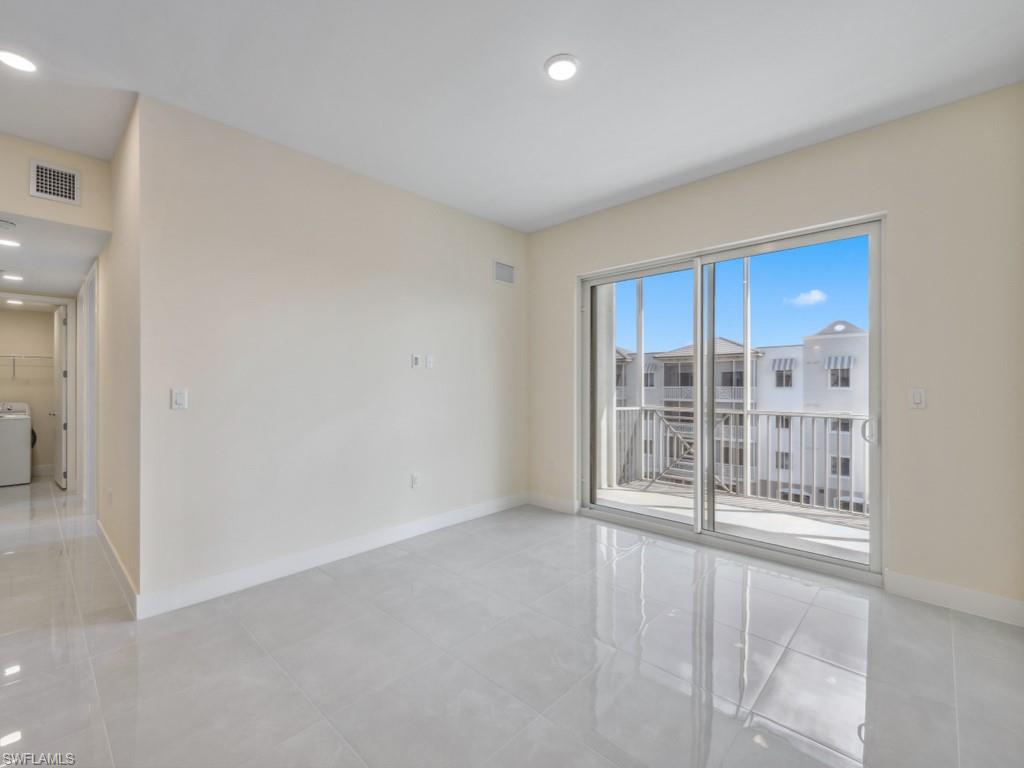 Spacious interior featuring light-toned walls, and large format tile flooring
