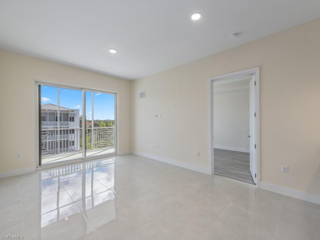 Spacious room featuring glossy light-toned tile flooring and recessed ceiling lighting