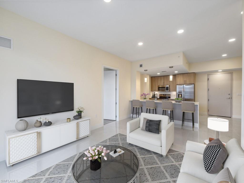 Virtually staged photo. Open-concept living area featuring polished tile flooring.