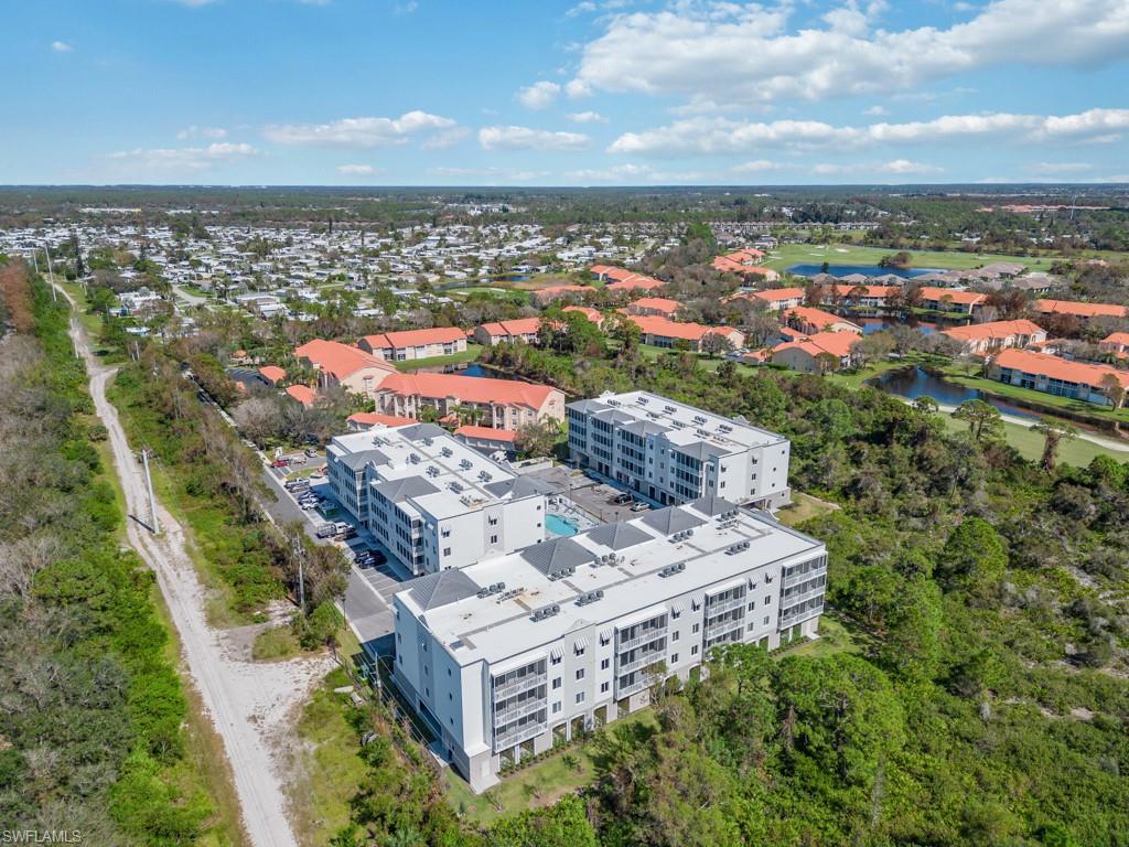 Aerial overview showcasing multiple multi-story residential buildings with balconies, surrounded by mature trees