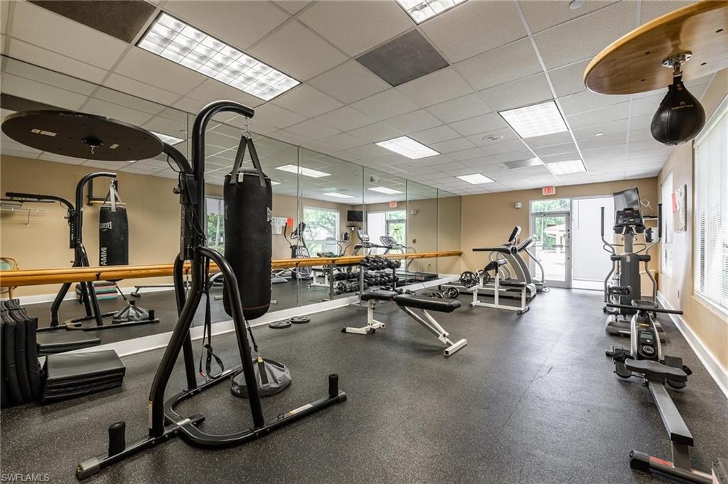 Fitness center featuring rubber flooring, mirrored walls, and recessed lighting