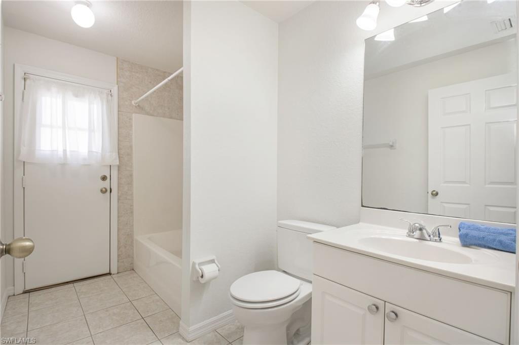 Bathroom featuring a white vanity with an integrated sink, polished chrome faucet, and a wall-mounted mirror