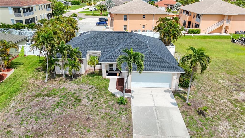 Modern residence featuring a dark shingle roof, attached garage, and a concrete driveway
