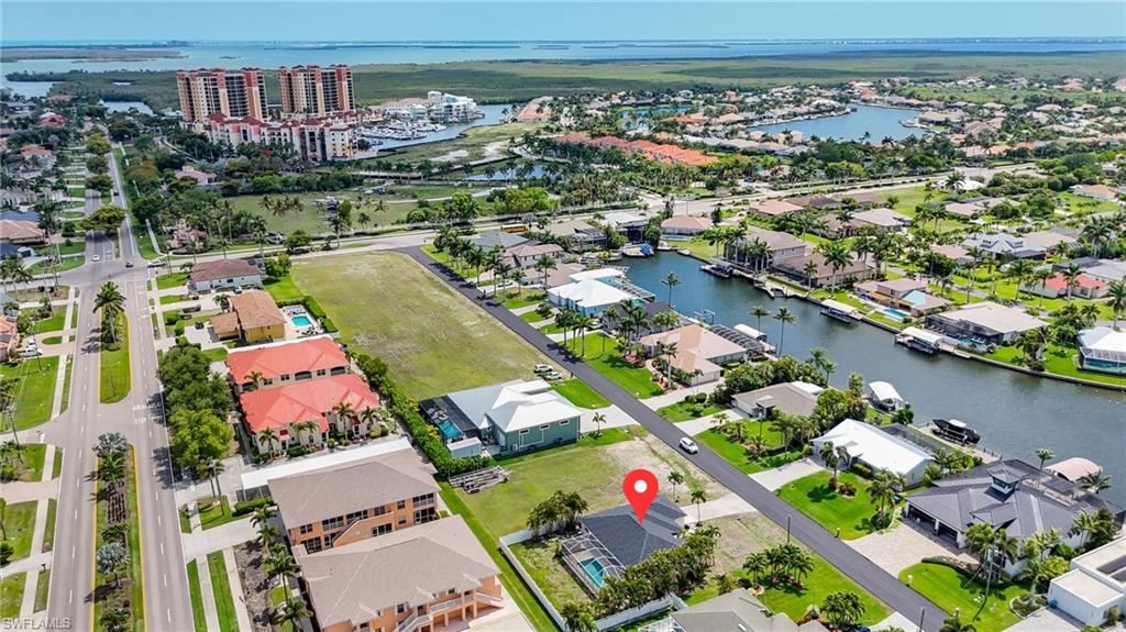Canal-front property featuring a private pool and mature landscaping