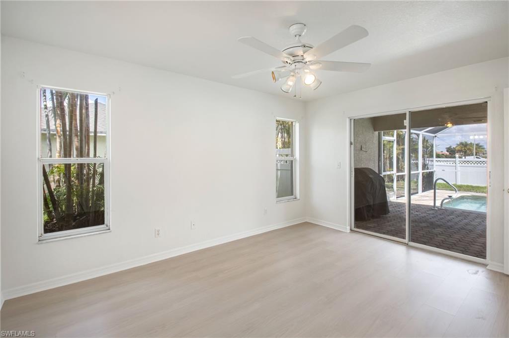 Spacious interior featuring light wood-finish flooring and a white ceiling fan with integrated lighting