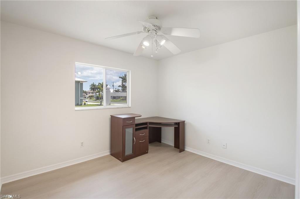 Neutral-toned room featuring a single window and wood-finish flooring