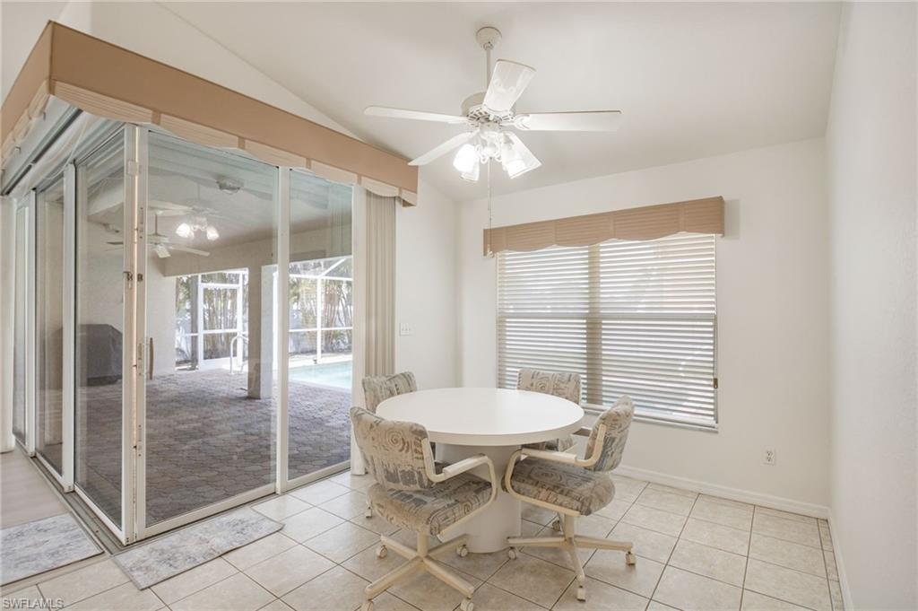 Tiled flooring extending to sliding glass doors with an awning, leading to an outdoor screened patio with paver flooring