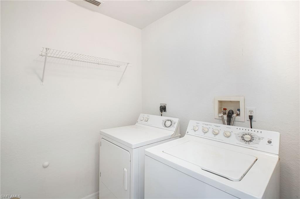 Dedicated laundry area featuring a white wire shelving unit, washing machine hookups, and electrical outlets