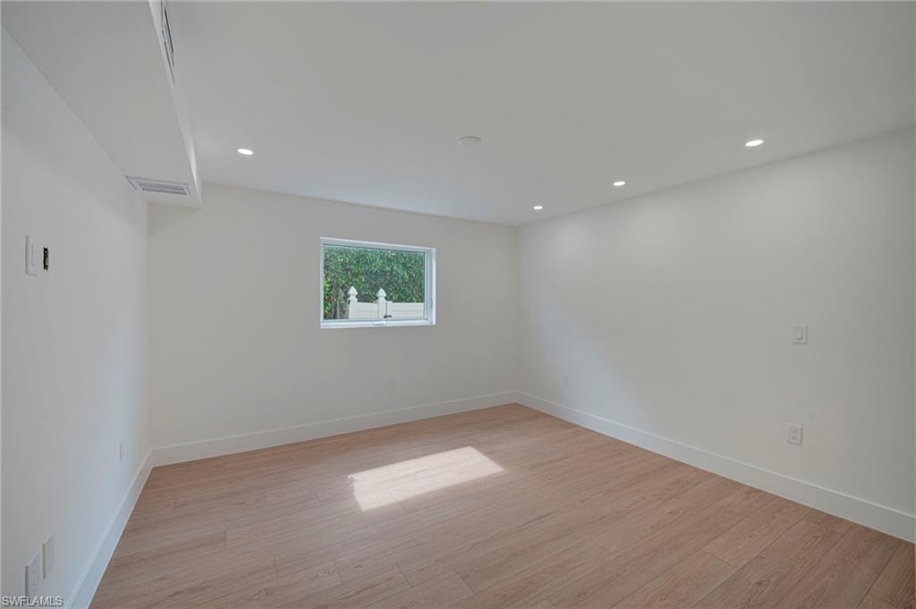 Bright interior space featuring light wood-finish flooring, recessed ceiling lighting, and a single window