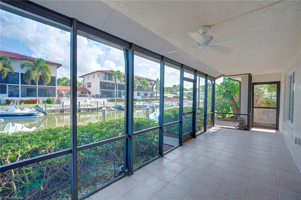Screened lanai featuring tile flooring and a ceiling fan