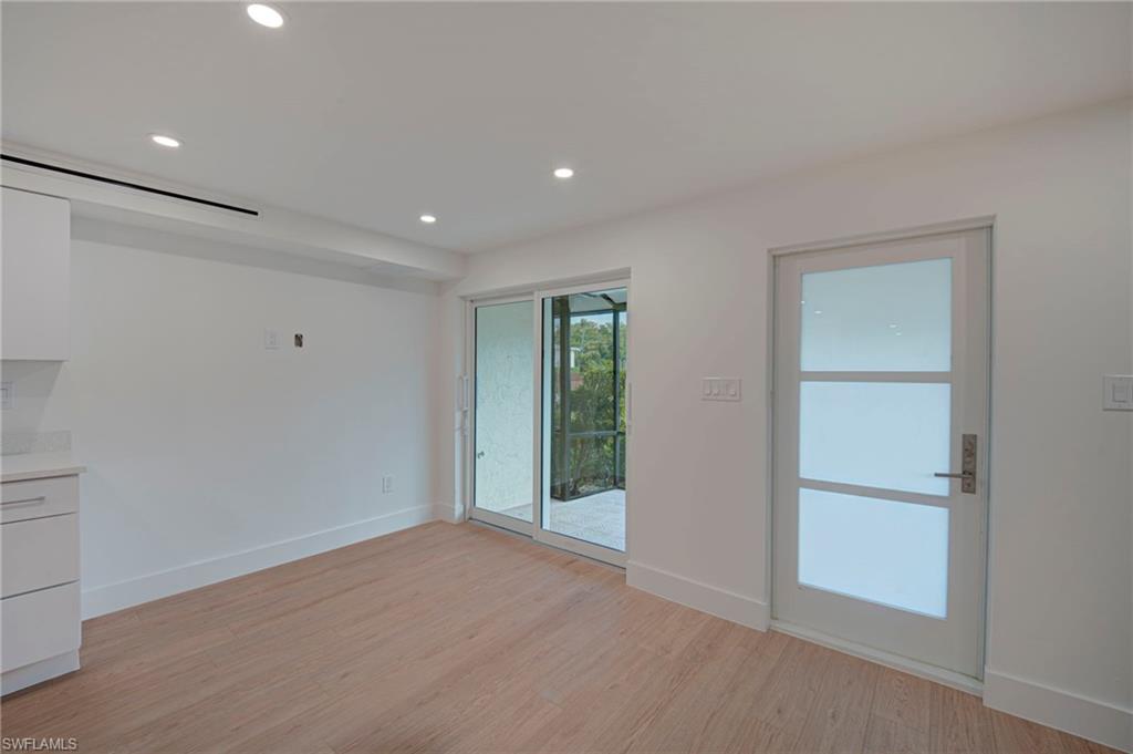 Light wood-finish flooring with white baseboards throughout