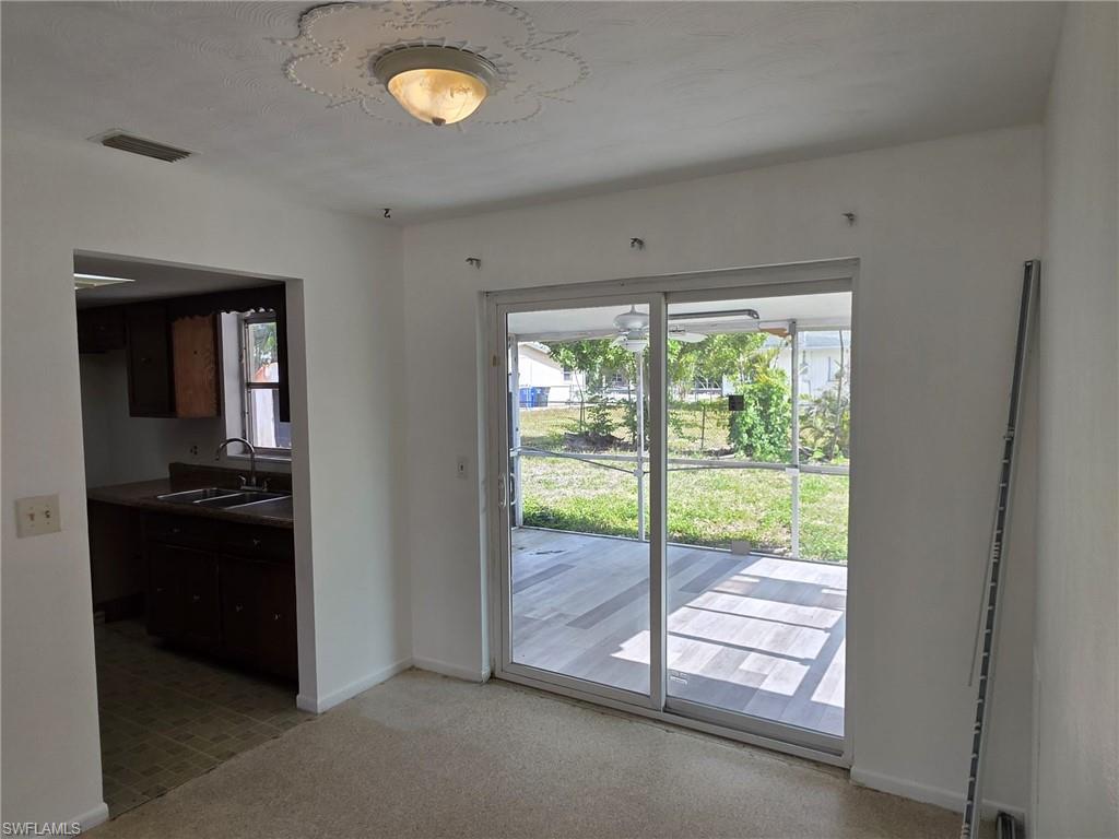Sliding glass doors opening to an outdoor patio with tiled flooring