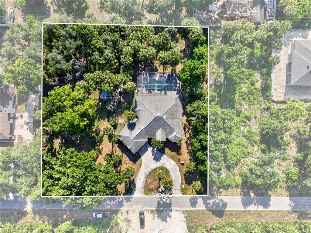 Expansive property featuring a large residence, a private tennis court, and a circular driveway