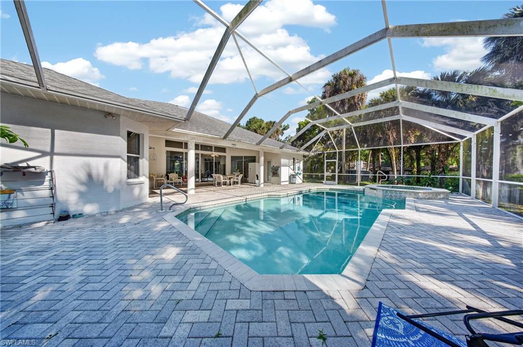 Screened outdoor living area featuring a geometric swimming pool with integrated spa