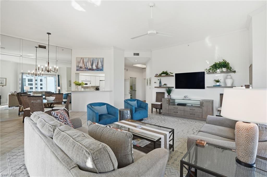 Spacious open-concept living area featuring high ceilings, contemporary lighting, and large format tile flooring