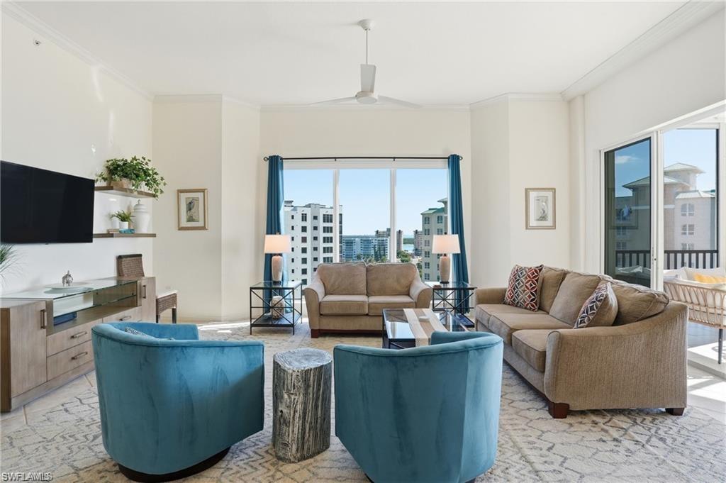 Spacious living area featuring expansive windows, crown molding, a ceiling fan, and direct access to an outdoor balcony