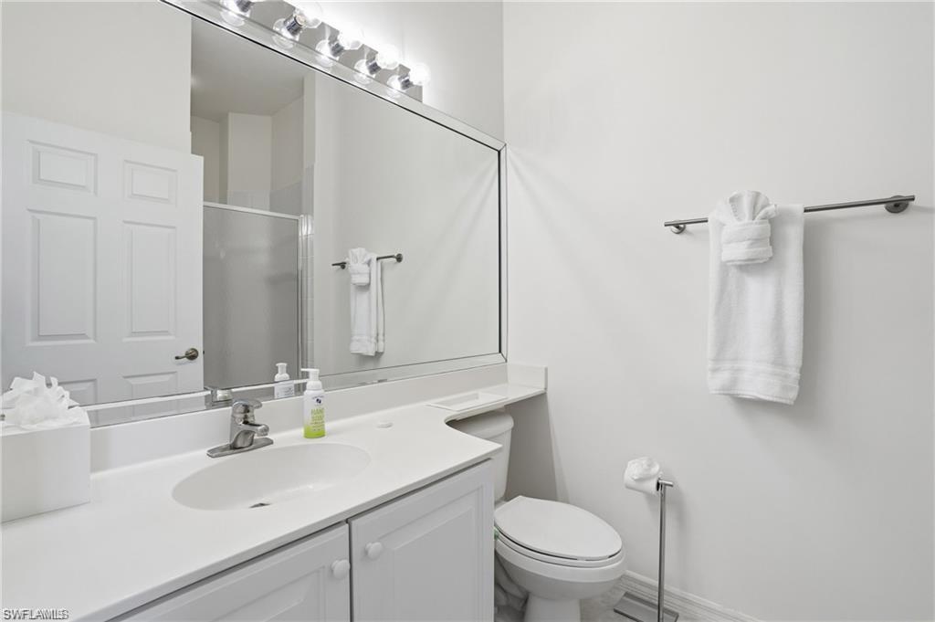 Bathroom featuring a spacious vanity with integrated sink, chrome faucet, and generous counter space