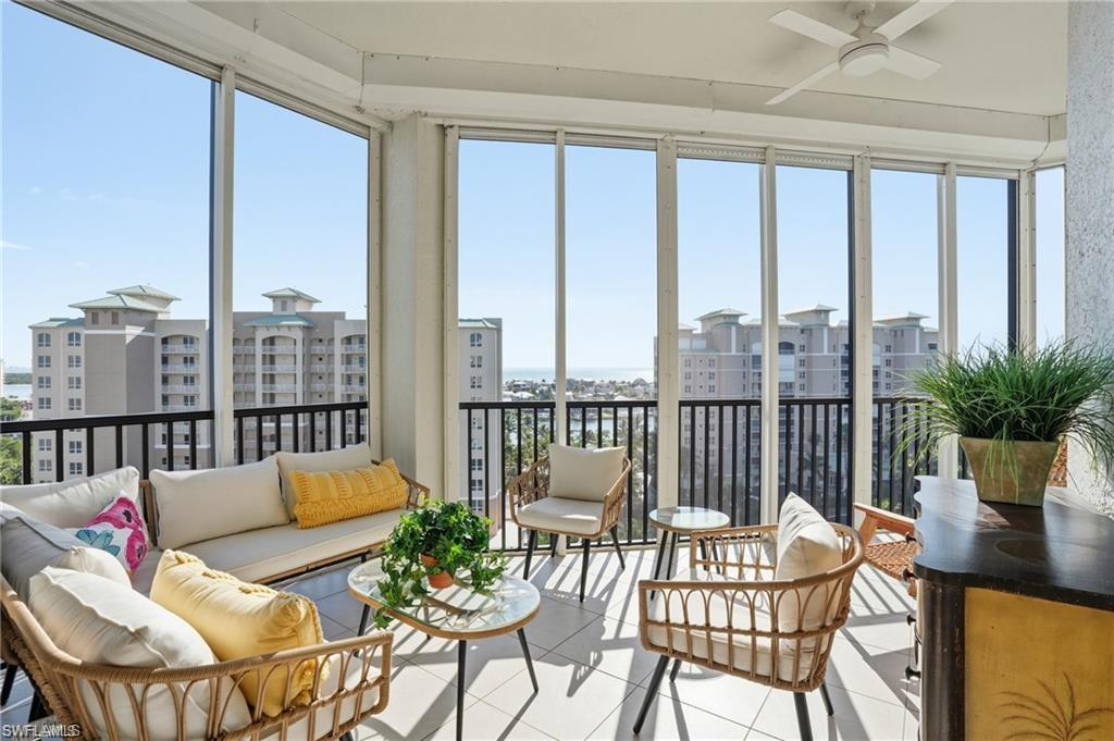Enclosed sunroom featuring floor-to-ceiling windows, a ceiling fan, and tile flooring