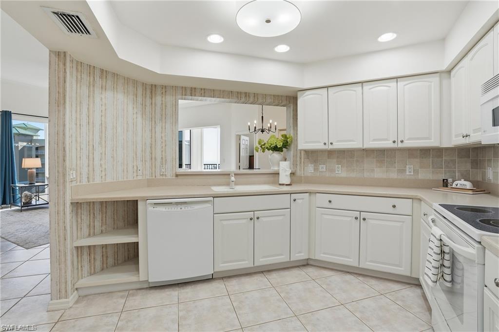Kitchen with white cabinetry, a neutral tiled backsplash, and light-toned countertops