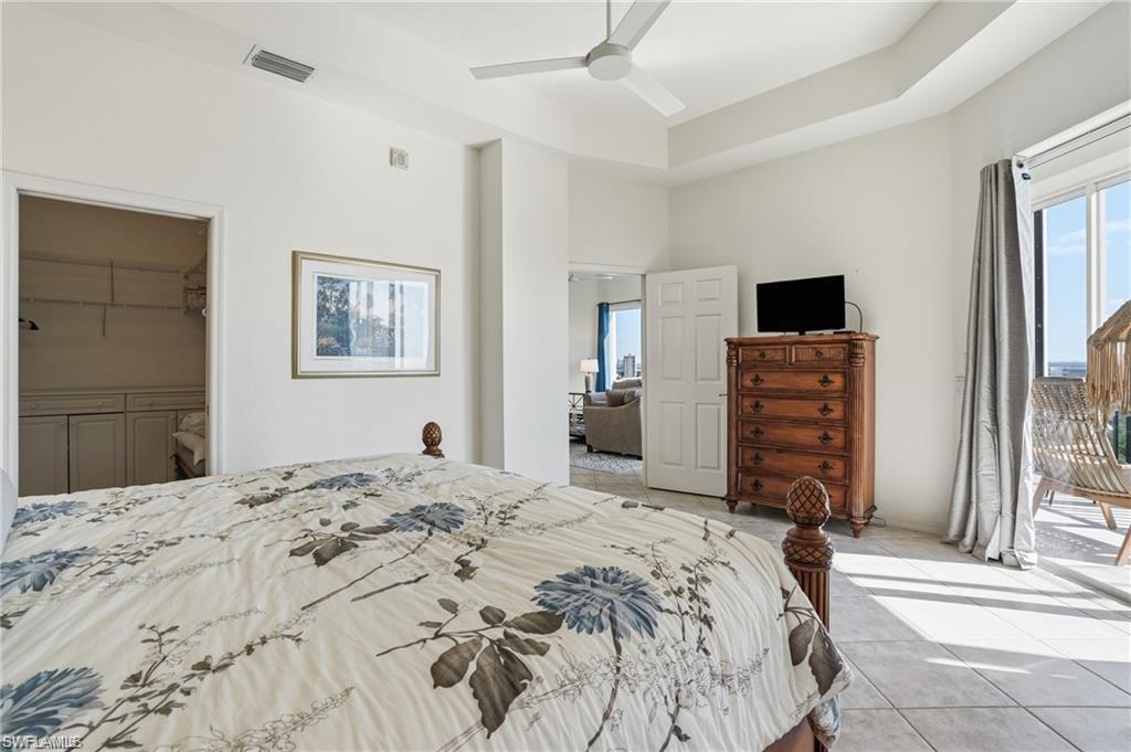 Spacious bedroom with tile flooring, a ceiling fan, and access to an outdoor balcony