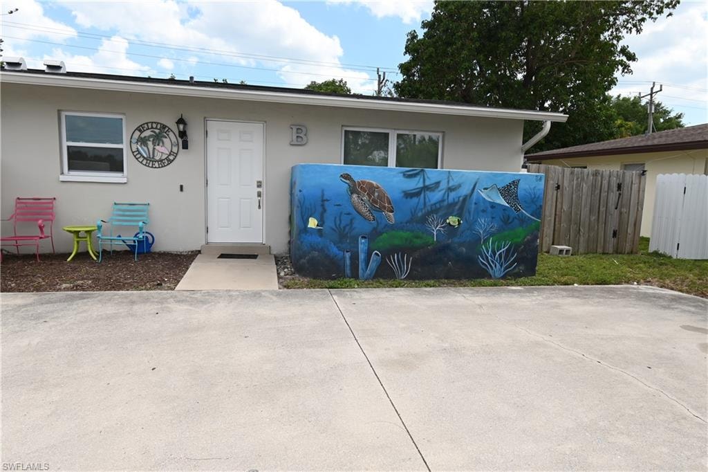 Exterior unit with a white front door, a prominent marine-themed mural, and a concrete driveway