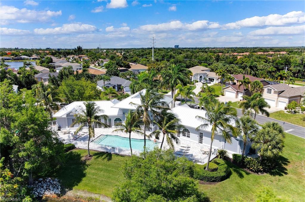 Expansive residence featuring a private swimming pool, surrounding patio, and lush tropical landscaping