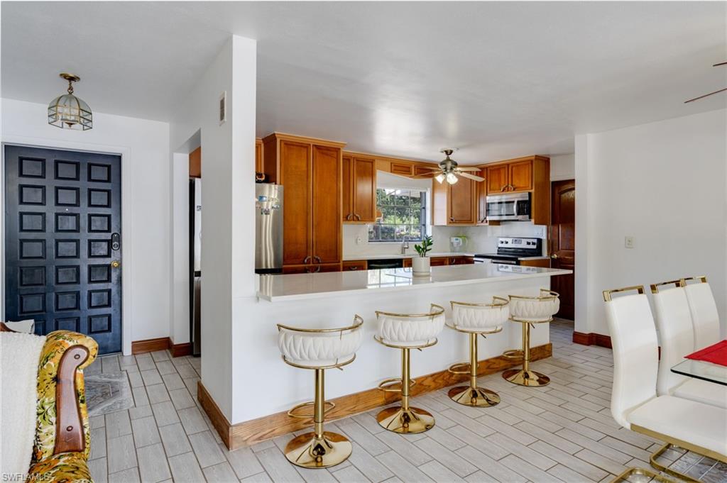 Kitchen featuring wood cabinetry, white countertops, and stainless steel appliances